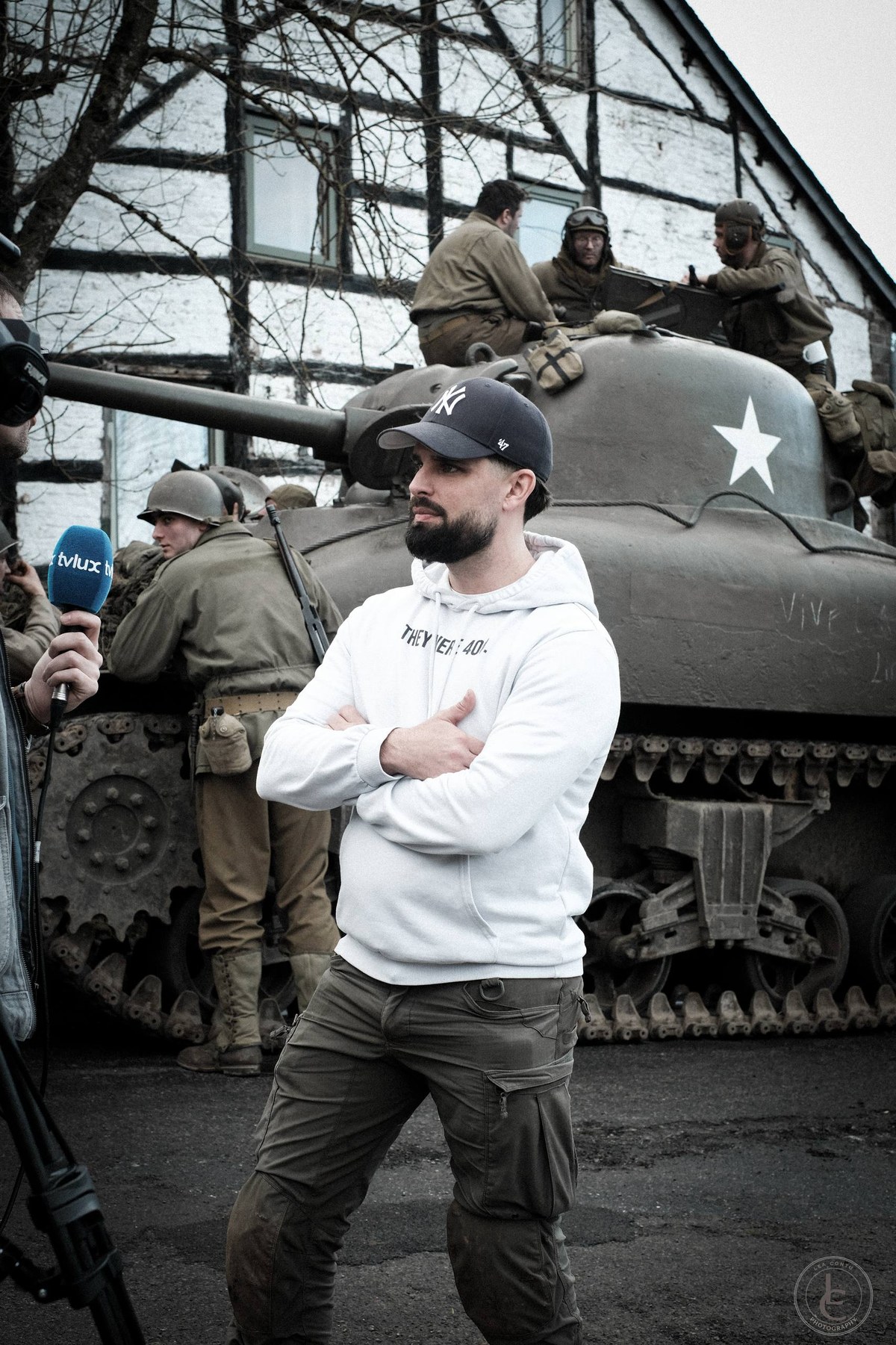 François Janssen being interviewed in front of a Sherman tank and reenactors at Marcouray